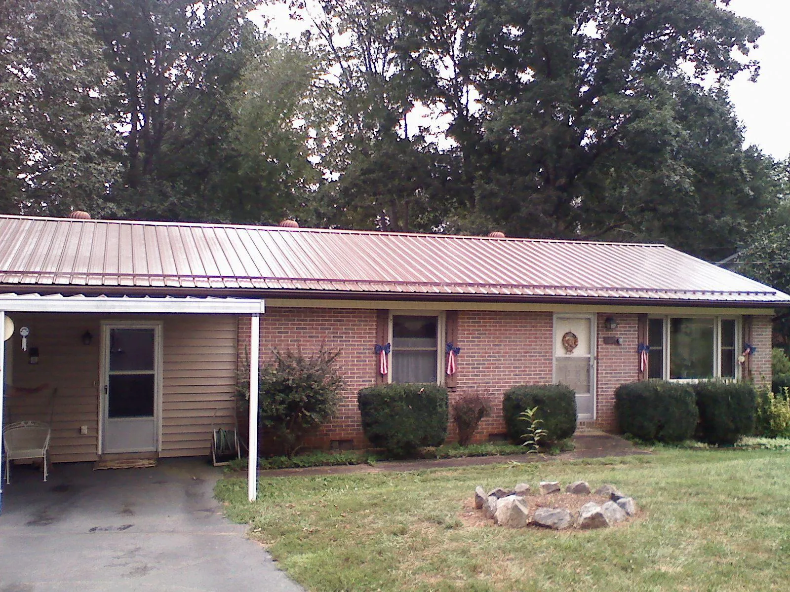 Bronze metal roof and carport on a brick ranch home — Roof Repair work by our crew in Spring Valley